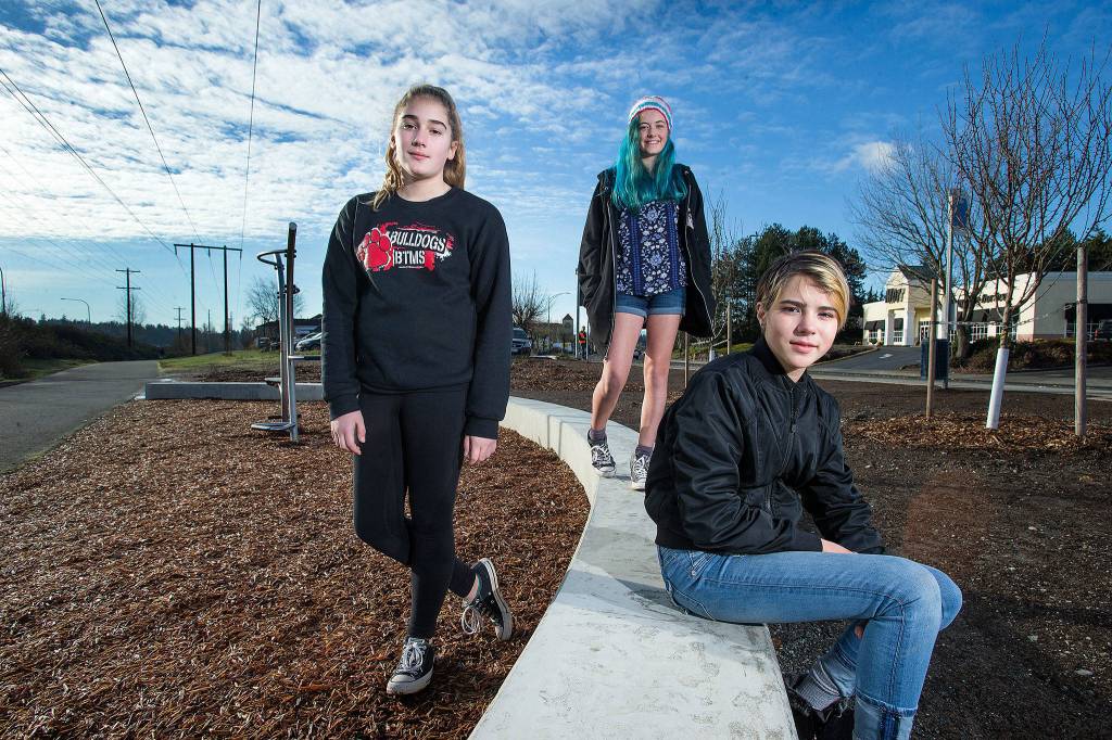 Lindsey Gard (from left), Inanna Liaw and Penny Campbell pose in a landscaped area of the Interurban Trail, where they planted blueberries and trees on Dec. 31, 2018, in Lynnwood. The three <a href="https://www.heraldnet.com/news/3-girls-40-blueberry-bushes-and-a-silver-award/" target="_blank">completed the project</a> as part of Girl Scout Troop 41246. (Andy Bronson / The Herald)