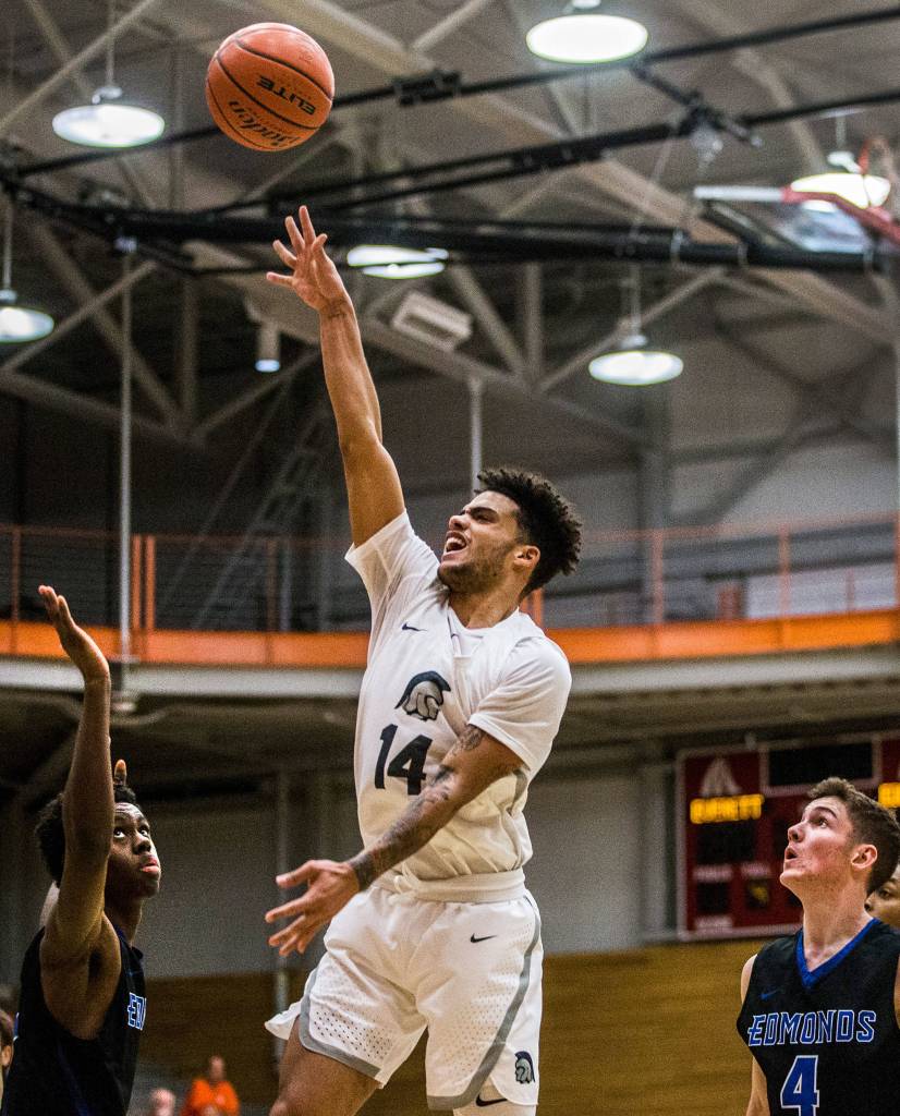 Everetts Phalon Maddox makes a jump shot while Edmonds Muhammed Kolly and Thomas Doyle watch the shot during the game on Jan. 19 in Everett. (Olivia Vanni / The Herald)