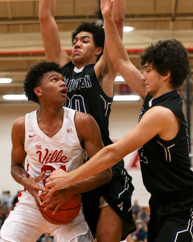 Marysville Pilchucks RaeQuan Battle gathers with Arlingtons Will Abram (back) and Arlingtons Michael Tsoukalas defending at Marysville Pilchuck High School on Jan. 23. The Tomahawks won 60-52. (Kevin Clark / The Herald)