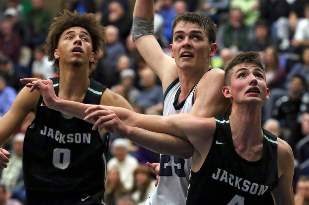 Jacksons Christian Liddell (left-right) Glacier Peaks Noah Forman and Jacksons Carter Korab look to rebound off a free throw at Glacier Peak High School Friday night in Snohomish on January 30, 2019. The Timberwolves won 47-44. (Kevin Clark / The Herald)