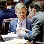Sen. Jamie Pedersen (left) D-Seattle, talks with a colleague on the Senate floor in Olympia on Wednesday. Pedersen introduced a bill Thursday that he says moves the Legislature toward more transparency  but within limits. (AP Photo/Ted S. Warren)