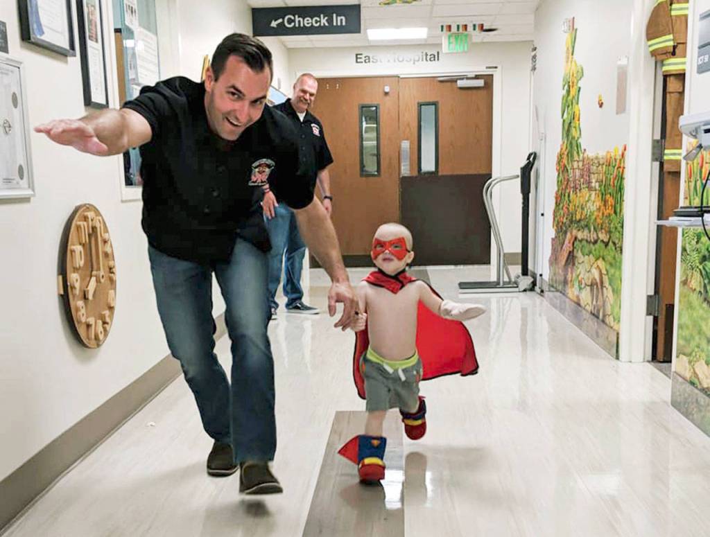 Driver/Operator Matt Suhayda plays with a child during a visit in July. (Snohomish County Fire District 7)