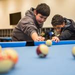 Jameson Schoentrup, 11, left, helps Javien Green, 9, right, with his shooting technique Jan. 24, at the Mukilteo Boys & Girls Club. (Olivia Vanni / The Herald)
