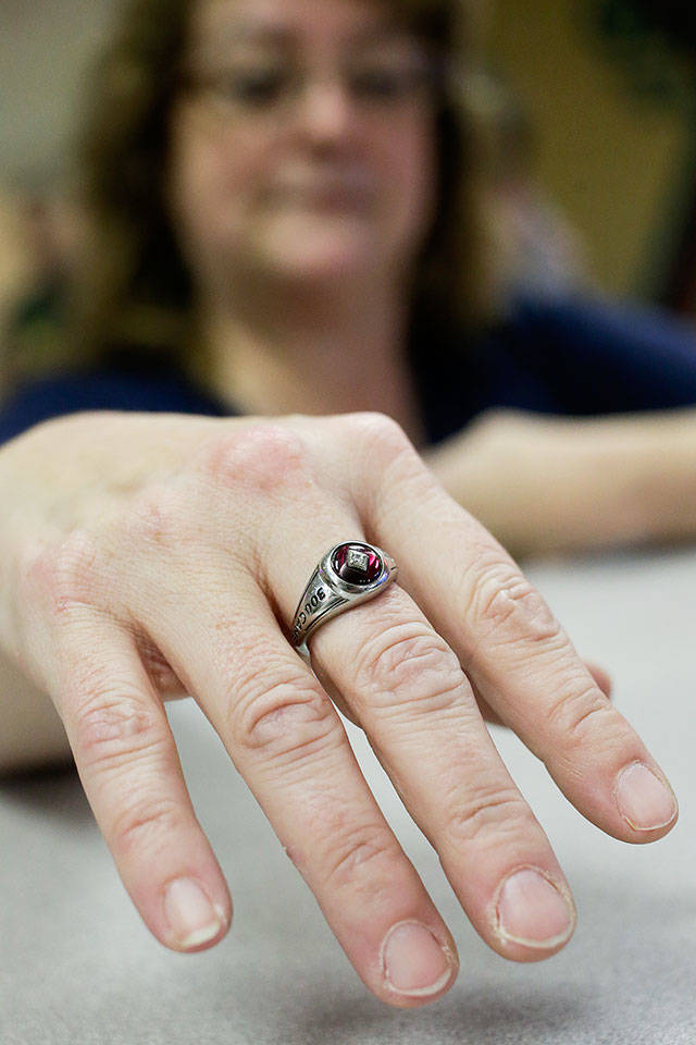 Family members Christie Aquilar shows her ring for bowling a perfect game, a 300, at Glacier Lanes on Monday, Jan. 28, 2019 in Everett, Wa. (Andy Bronson / The Herald)
