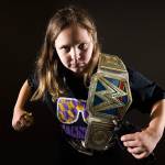 Annabelle Davis, 11, with her two championship belts, Macho Man Randy Savage shirt and figures of John Cena and The Undertaker, is an avid WWE fan. (Andy Bronson / The Herald)