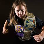 Annabelle Davis, 11, with her two championship belts, Macho Man Randy Savage shirt and figures of John Cena and The Undertaker, is an avid WWE fan. (Andy Bronson / The Herald)