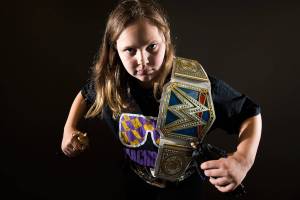 Annabelle Davis, 11, with her two championship belts, Macho Man Randy Savage shirt and figures of John Cena and The Undertaker, is an avid WWE fan. (Andy Bronson / The Herald)