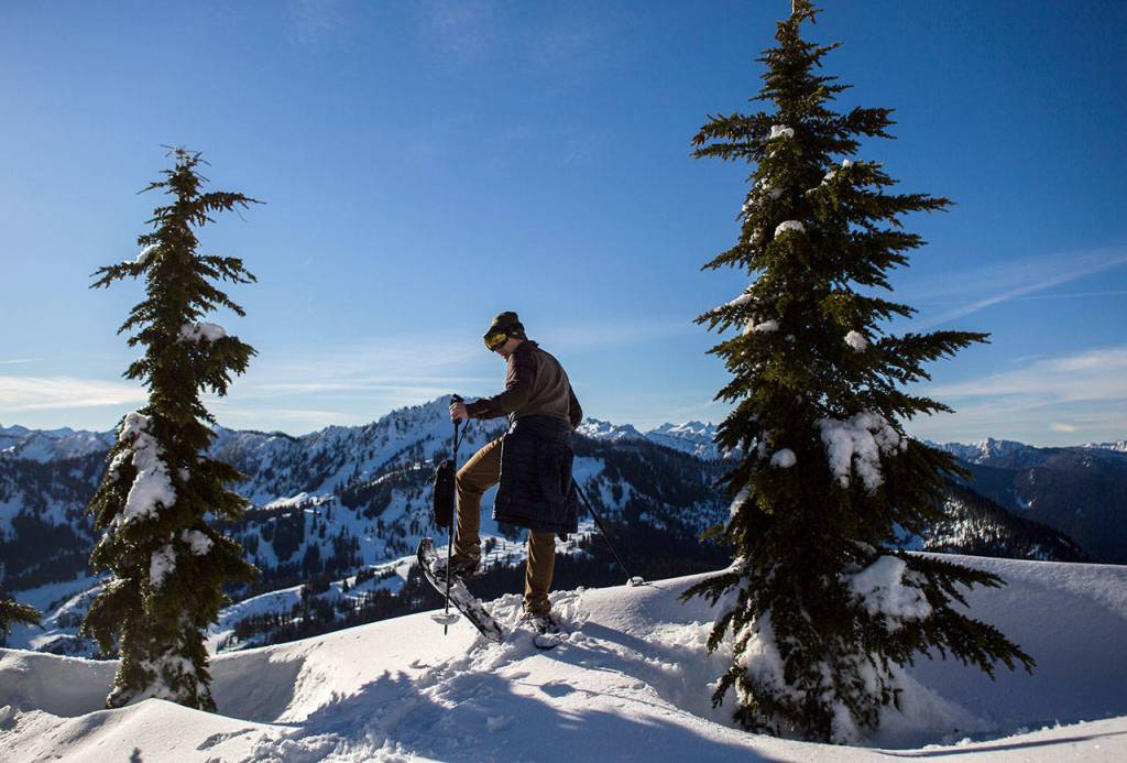 Kyle James looks out at Stevens Pass from a ridge line on the Skyline Lake Trail. (Olivia Vanni / The Herald)