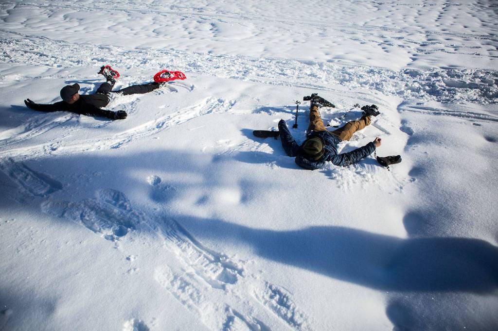 Don Sarver, left, and Kyle James, right, make snow angels on the Skyline Lake Trail on Saturday, Jan. 26, 2019 in Leavenworth, Wa. (Olivia Vanni / The Herald)