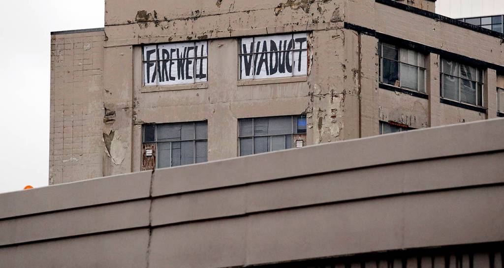 A Farewell Viaduct sign stands in view of the north portal of the new State Route 99 tunnel on Friday. The two-mile, double-deck highway running under downtown is set to open to traffic Monday, Feb. 4, and replaces the old Alaskan Way Viaduct, damaged in an earthquake in 2001. (AP Photo/Elaine Thompson)