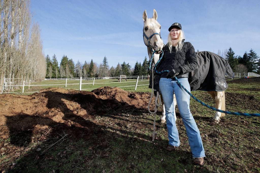 With her horse Joe next to her, Melonie Rainey of White Birch Farm talks about her participation in the Conservation Districts <a href="https://www.heraldnet.com/news/managing-manure-saves-money-local-streams/" target="_blank">horse manure spreading program</a> on Jan. 28 in Tulalip. The program helps horse owners keep manure under control, turn it into fertilizer and use it on their pastures. (Andy Bronson / The Herald)