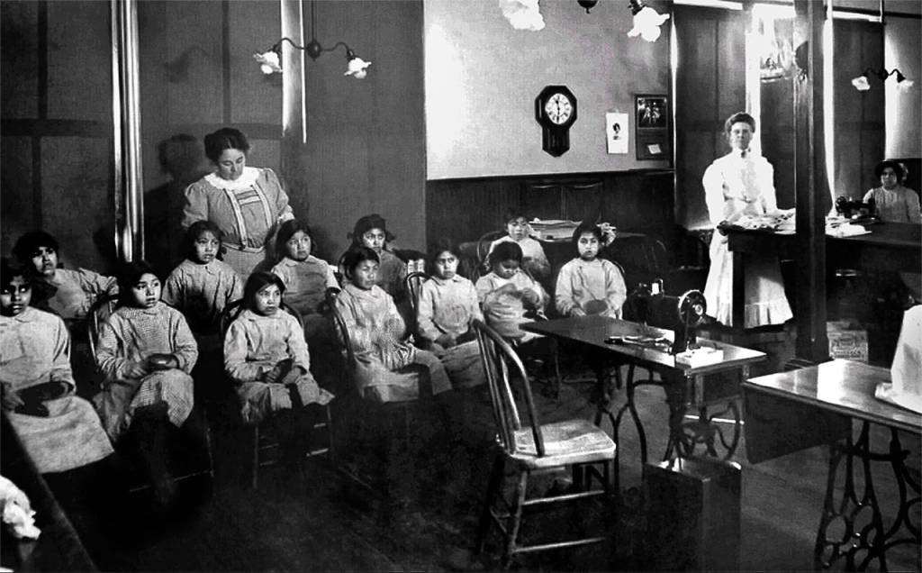 Girls at the Tulalip Indian Boarding School warily eye a sewing machine as they learn about required duties. Harriette Shelton Dover attended this school from age 7 until her graduation in 1922. (Tulalip Tribes Hibulb Cultural Center)
