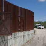 A U.S. Customs and Border Patrol vehicle passes along a section of border levee wall in Hidalgo, Texas, in 2017. The U.S. government is preparing to begin construction of more border walls and fencing in South Texas Rio Grande Valley, likely on federally-owned land set aside as wildlife refuge property. Heavy construction equipment is supposed to arrive starting Monday. A photo posted by the nonprofit National Butterfly Center shows an excavator parked on its property. (AP Photo/Eric Gay, File)