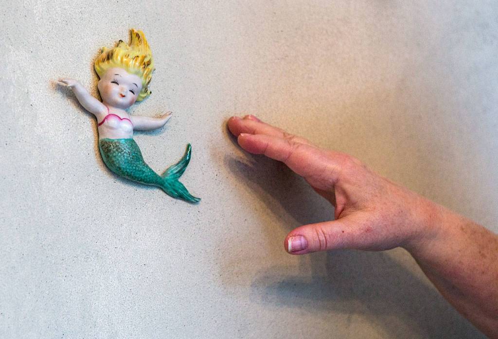 Melissa Strash points out the mermaid that started her love for mermaid collectibles. (Olivia Vanni / The Herald)