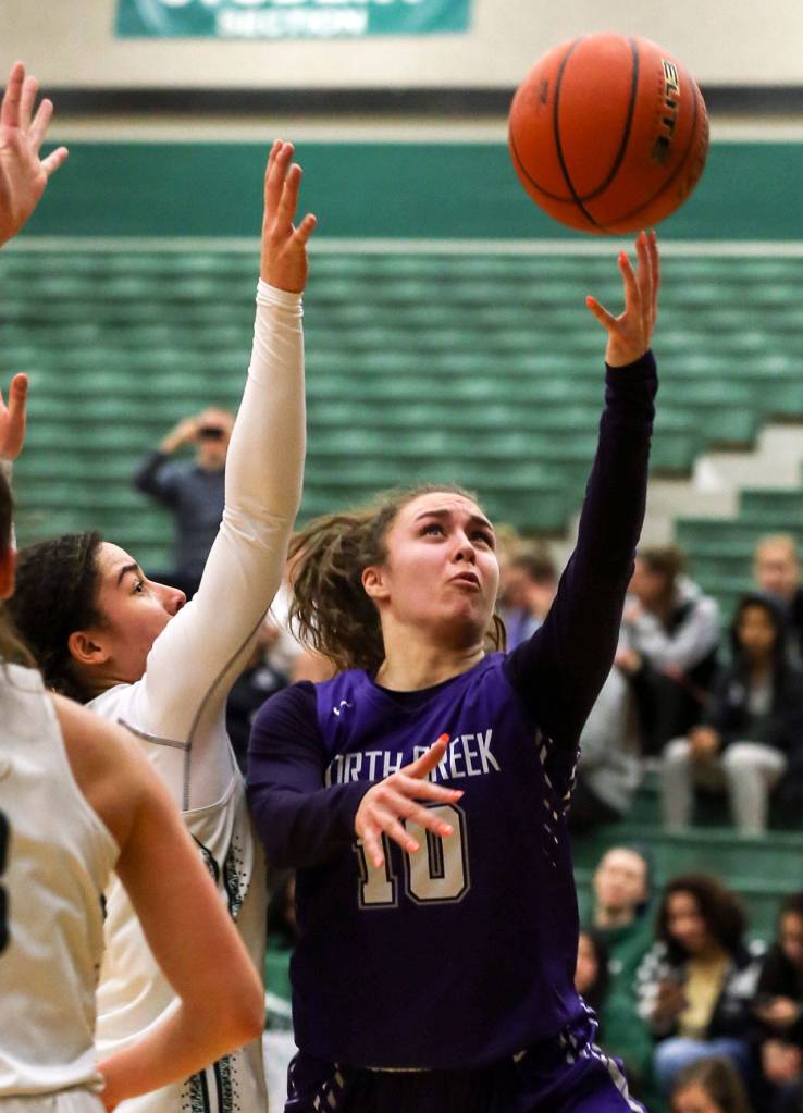 North Creeks Lexi Ducheane (right) attempts a shot around the defense of Jacksons Jaelen Williams during a 4A Wes-King District Tournament play-in game Thursday at Jackson High School in Mill Creek. North Creek beat the Timberwolves 84-70. (Kevin Clark / The Herald)