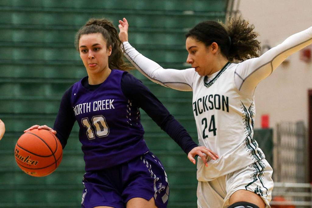 North Creeks Lexi Ducheane (left) brings the ball upcourt with Jacksons Jaelen Williams defending during a 4A Wes-King District Tournament play-in game Thursday at Jackson High School in Mill Creek. North Creek beat the Timberwolves 84-70. (Kevin Clark / The Herald)