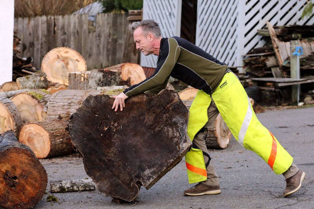 Shane McDaniel relocates wood at his home Jan. 12, in Lake Stevens. His good deeds landed him on a dating show segment during the Steve Harvey talk show, where McDaniel and his twin sons chose from three eligible bachelorettes, including a woman from Lake Stevens. (Kevin Clark / The Herald)