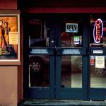 Edmonds Theater door glass reflects the bustling foot and auto traffic on Main Street. (Dan Bates / The Herald)