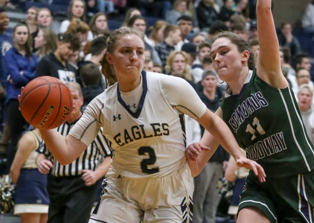Arlingtons Hailey Hiatt makes a pass with Edmonds-Woodways Ingrid Rosberg defending during the 3A district tournament Friday night at Arlington High on February 15, 2019 in Arlington. The Eagles won 55-38. (Kevin Clark / The Herald)