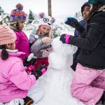 From left, Alexa Urbanozo, 6, Evie Larama, 6, Reese Emerson, 9, Tegan Larama, 9, and Ava Urbanize, 9, work on a snowman on Feb. 9 in Everett. (Olivia Vanni / The Herald)