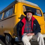 <a href="https://www.heraldnet.com/news/hes-the-man-whose-yellow-vw-van-gets-attention-in-edmonds/" target="_blank">Steven Bell</a> sits on the bumper of his 1976 Volkswagen Westfalia Transporter parked on Sunset Avenue on Jan. 29 in Edmonds. (Olivia Vanni / The Herald)