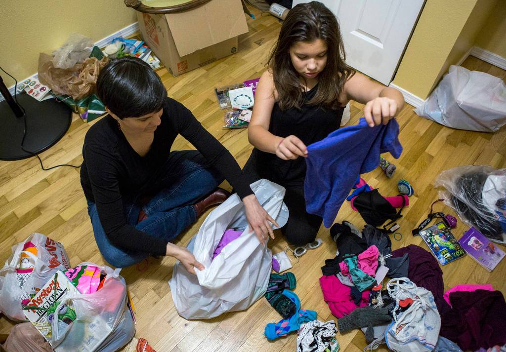 Diane Bradford (left) and her daughter Sierra Lindenstein, 11, <a href="https://www.heraldnet.com/news/does-declutter-diva-marie-kondo-spark-joy-or-misery/" target="_blank">sort through clothing</a> at their home on Jan. 20 in Lynnwood. (Olivia Vanni / The Herald)