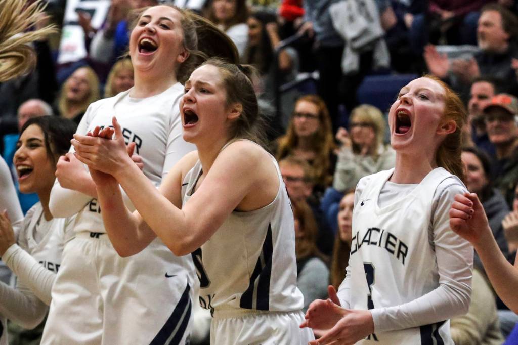 Players cheer the action on the court at Glacier Peak High School in Snohomish on Feb. 14. The Grizzles won 57-37. (Kevin Clark / The Herald)