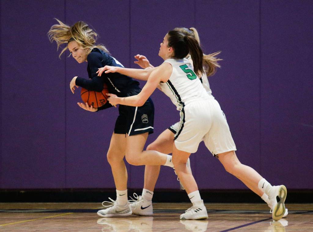 Glacier Peaks Sydney Guffey strips the ball away from two Woodinville players. (Andy Bronson / The Herald)