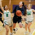 Glacier Peaks Maya Erling attempts a layup after splitting two Woodinville defenders. (Andy Bronson / The Herald)