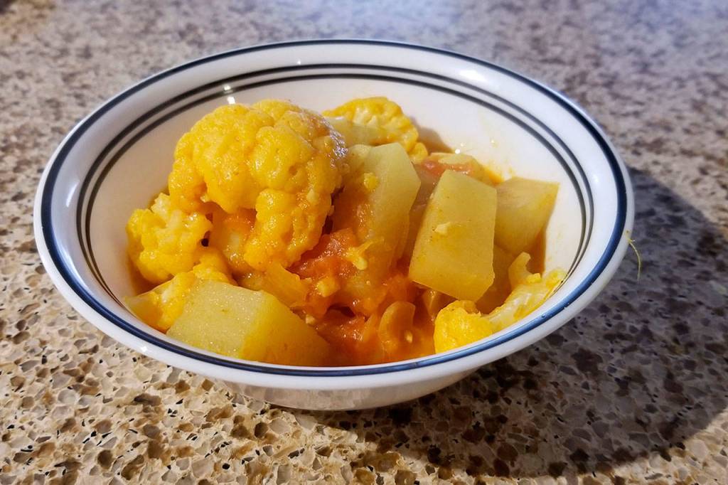 Potato-cauliflower curry is a hearty Indian dish best served hot. (Megan Campbell / The Herald)