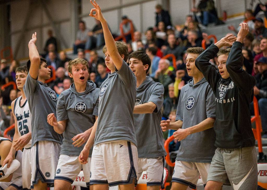 The Glacier Peak bench reacts to a teammates 3-point shot during Fridays 4A state regional game against Issaquah at Everett Community College. (Olivia Vanni / The Herald)