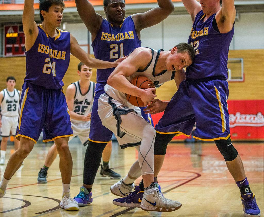 Glacier Peaks Fletcher Douglas (center) fights for the ball during Fridays 4A state regional game against Issaquah at Everett Community College. (Olivia Vanni / The Herald)