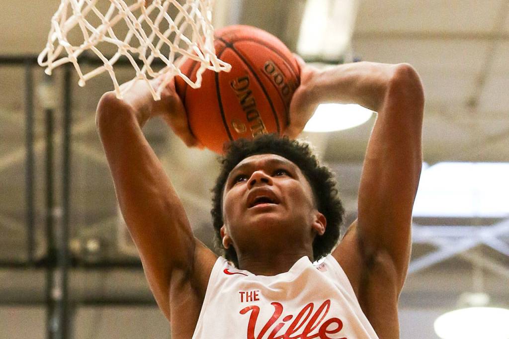 Marysville Pilchucks RaeQuan Battle dunks against Kelso during a state regional boys basketball game Feb. 23 at Everett Community College. The Tomahawks won 72-51. (Kevin Clark / The Herald)