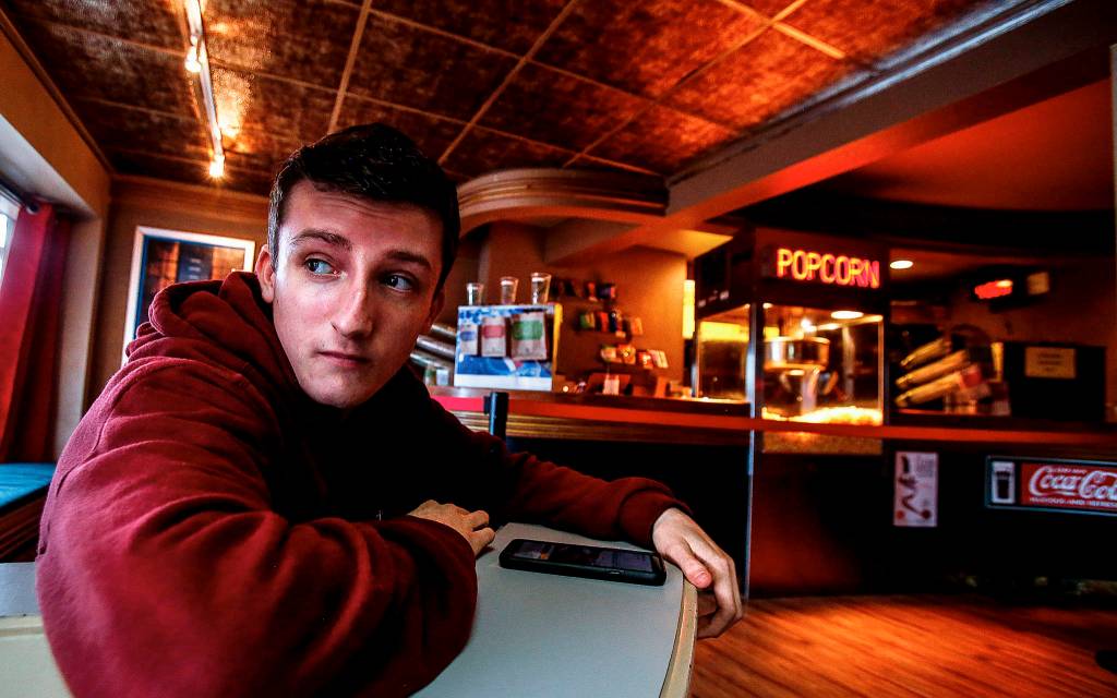 From the <a href="https://www.heraldnet.com/news/edmonds-movie-house-is-classic-but-many-films-are-first-run/" target="_blank">Edmonds Theater</a>s distinctive Art Deco lobby, employee Jack Eccleshall, 18, glances out front windows that frame scenes along Main Street. (Dan Bates / The Herald)