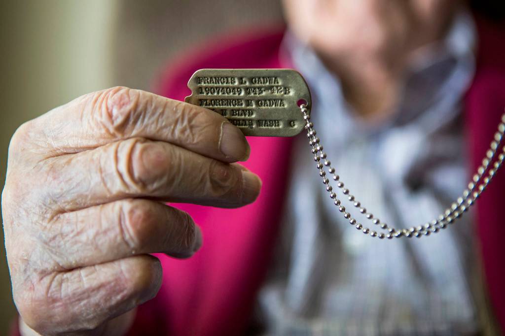 <a href="https://www.heraldnet.com/news/frank-gadwa-the-last-of-the-greatest-generation/" target="_blank">Frank Gadwa</a> holds up his dog tag on Feb. 13 in Marysville. (Olivia Vanni / The Herald)