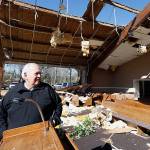 Pastor Steve Blaylock looks over the broken lumber, loose paneling, insulation, and destroyed pews in the First Pentecostal Church in Columbus, Mississippi, on Sunday morning after a Saturday tornado. While no-one was injured during the storm, at least one person was killed in town among the shattered businesses and wrecked homes. (AP Photo/Rogelio V. Solis)