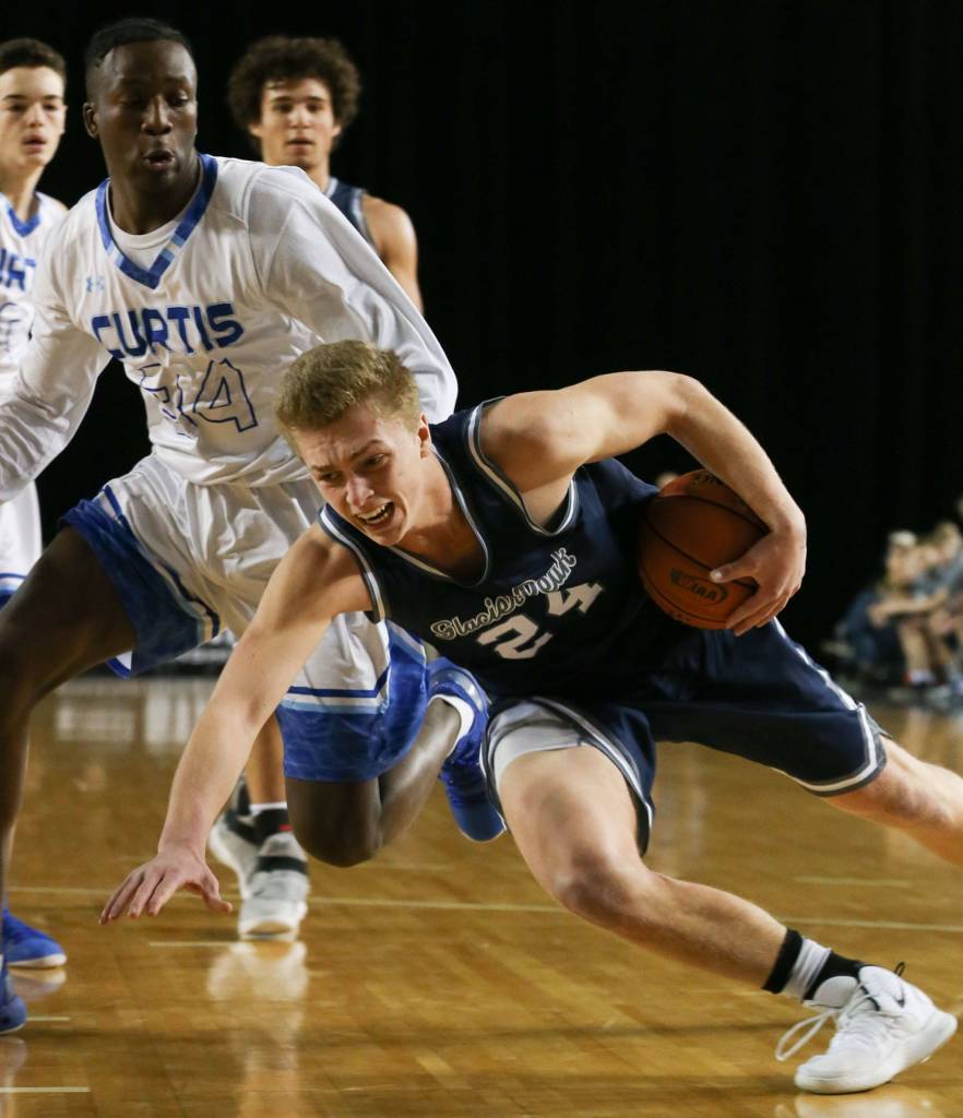Glacier Peaks Evan Mannes slips drives to the basket with Curtis Isaac Morrow looking on Wednesday afternoon at the Tacoma Dome on February 27, 2019. The Grizzles lost 46-43. (Kevin Clark / The Herald)