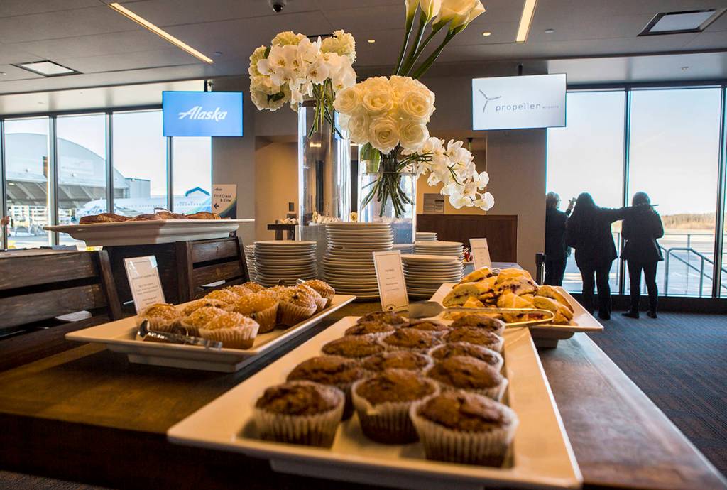 People enjoy free food and views of the Olympic Mountains during the grand opening of the Paine Field passenger terminal on Monday. (Olivia Vanni / The Herald)