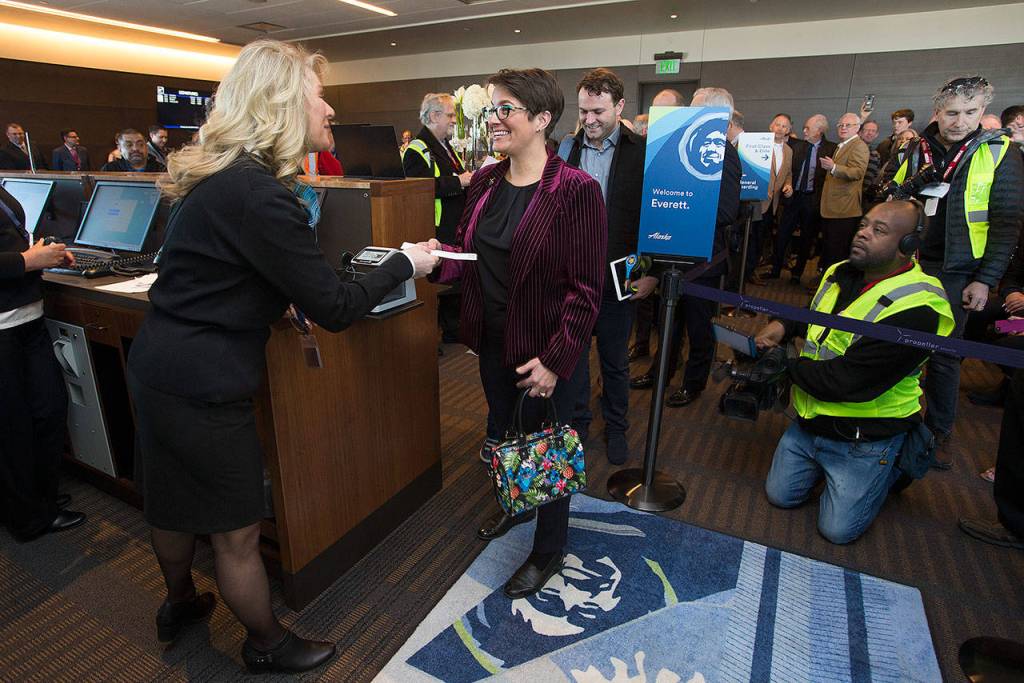 Everett Mayor Cassie Franklin smiles as she gets her ticket to board the first passenger flight Monday, the opening day of the Paine Field terminal in Everett. (Andy Bronson / The Herald)