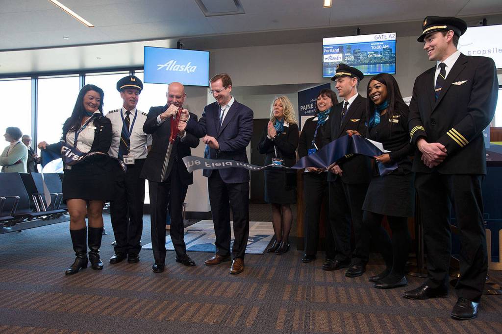 President and CEO of Horizon Air Gary Beck, left, and Alaska Airlines Chief Commercial Officer Andrew Harrison cut a ribbon on opening day of the Paine Field passenger terminal on Monday. (Andy Bronson / The Herald)