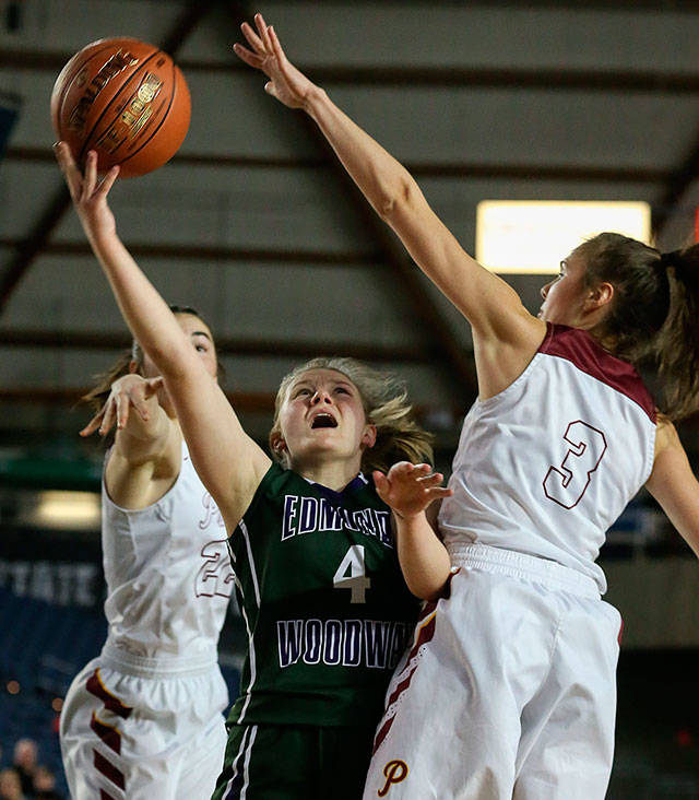 Edmonds-Woodways AJ Martineau attempts a layup past Prairies Haley Reed (left) and Meri Dunford during a Hardwood Classic game at the Tacoma Dome on Feb. 28. (Kevin Clark / The Herald)