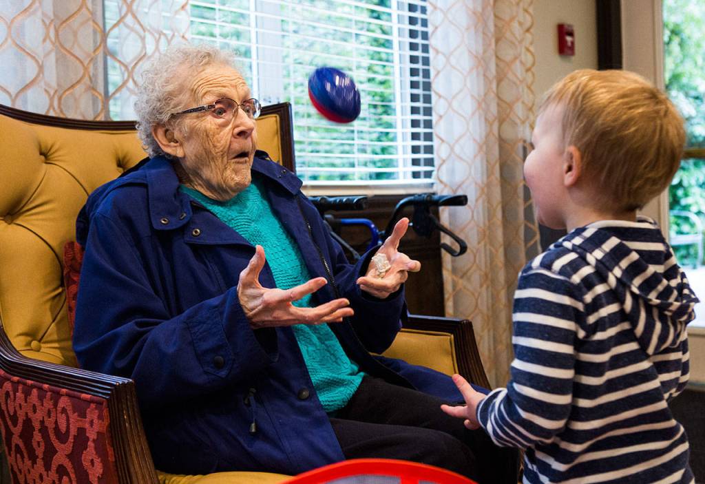 Dorris Johnson, 93, plays catch with Jaxson Bates, 3, during the Seniors & Sprouts program at Pacifica Senior Living in Lynnwood. (Olivia Vanni / The Herald)
