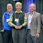 Trinity Lutheran Church Pastor Hector Garfias-Toledo (center) accepts the Service to our Community Award on behalf of Neighbors in Need from (left to right) Verdant Superintendent Dr. Robin Fenn, Commissioner Dr. Jim Distelhorst, Commissioner Fred Langer, and Commissioner Bob Knowles at the Verdant Healthier Community Conference.