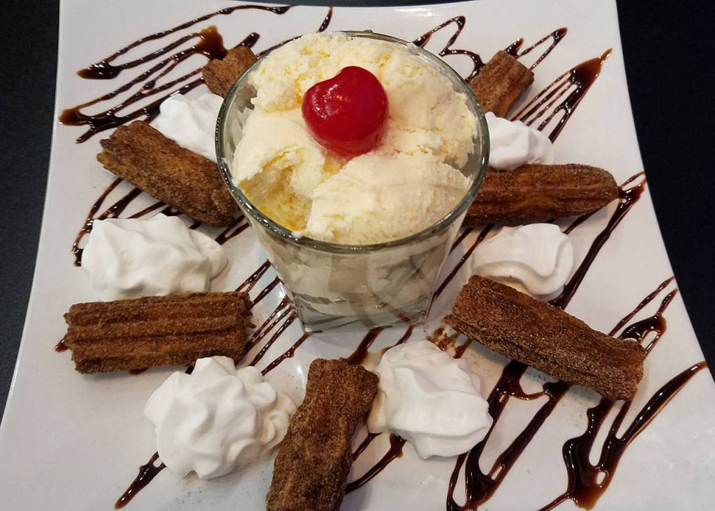 These cinnamon covered churros are served with whipped cream, ice cream and chocolate sauce. (Sharon Salyer/The Herald)