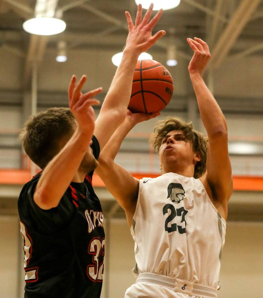 Everett Community Colleges Magnus Jespersen (right) shoots over Olympics Calvin Dennis during a Feb. 20 NWAC mens basketball game in Everett. (Kevin Clark / The Herald)