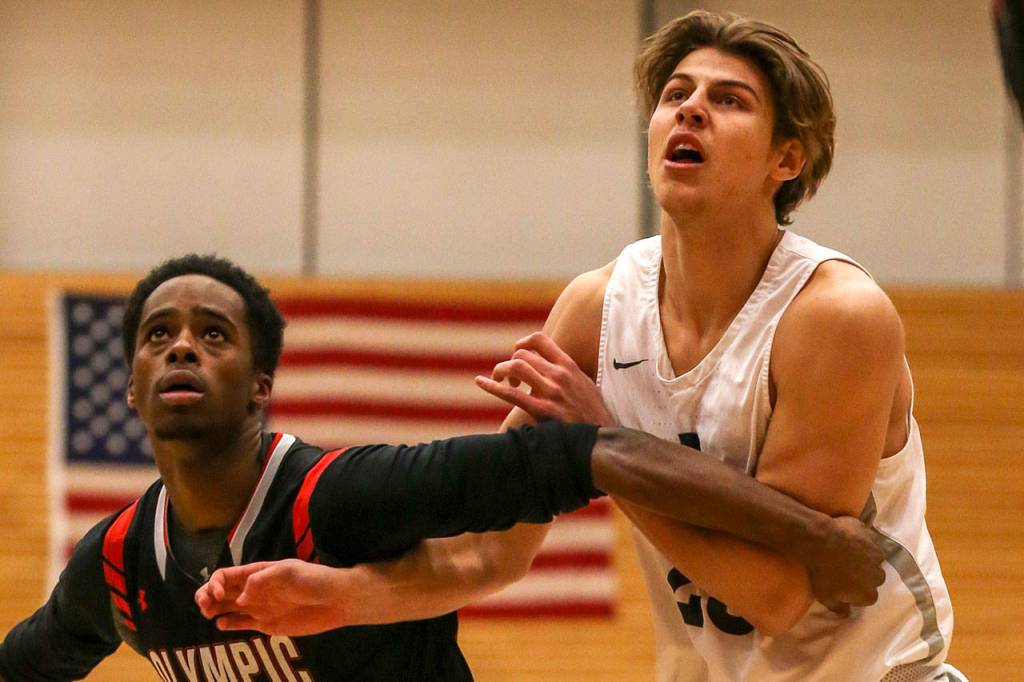 Everett Community Colleges Magnus Jespersen (right) battles for a rebound with Olympics Ronnie Smallwood Jr. (left) during an NWAC mens basketball game on Feb. 20 in Everett. (Kevin Clark / The Herald)