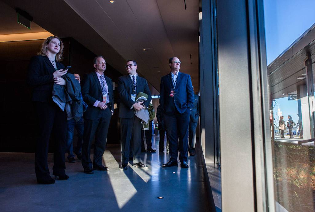 Paine Field Airport employees watch the statue unveiling during the grand opening of the Paine Field Airport on March 4 in Everett. (Olivia Vanni / The Herald)