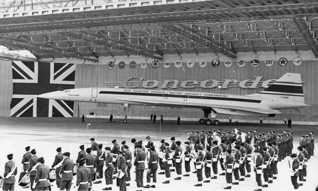 In this Dec. 11, 1967 photo, members of the French army band (front) and Royal air Force Band stand in front of the British-French supersonic airliner Concorde during its official presentation in Toulouse, France. (AP Photo/Peter Kem, File)