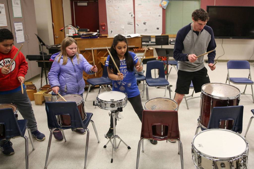 Pat Jameson (right) leads the drum line during practice at Challenger Elementary in Everett. From left, Andric Villanueva-Romero, Teagan McLaughlin-Clausen and Lynette Milly Milagros.                                (Kevin Clark / The Herald)