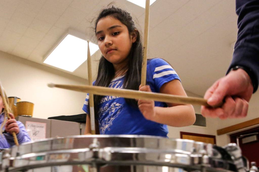 Lynette Milly Milagros pounds a beat during practice at Challenger Elementary in Everett. (Kevin Clark / The Herald)